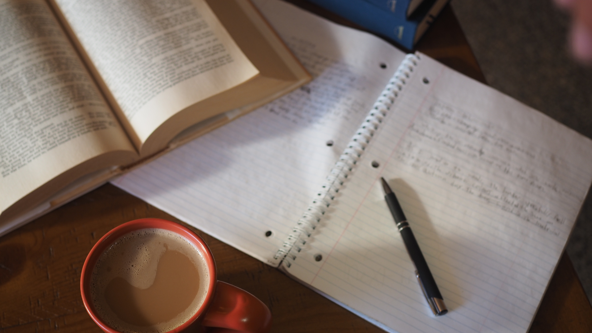 Image description of what to expect-A cup of coffee, a book and a pen.
